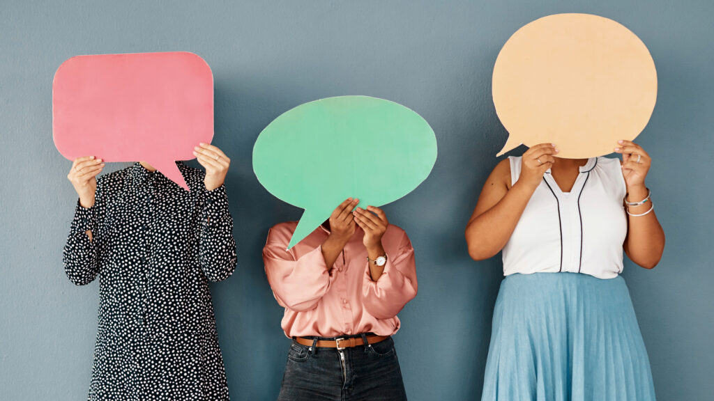 photo of women holding paper speech balloons to represent communication quotes